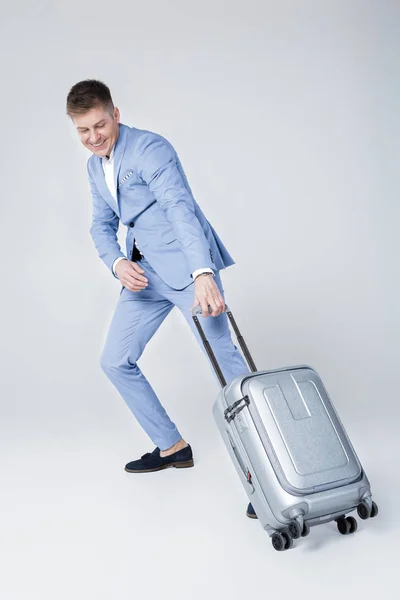 Молодий чоловік у синьому костюмі з валізою — стокове фото