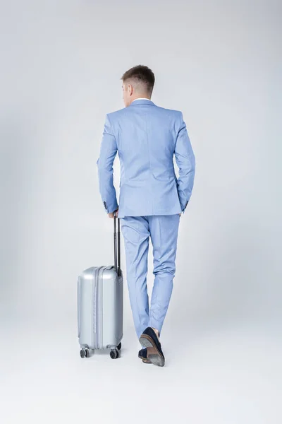 Hombre joven en traje azul con maleta — Foto de Stock