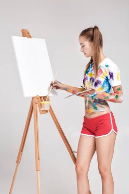 renkli boya lekeli kadın ressam tuval üzerine çizer.