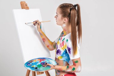renkli boya lekeli kadın ressam tuval üzerine çizer.