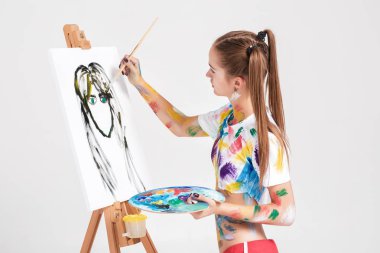 renkli boya lekeli kadın ressam tuval üzerine çizer.