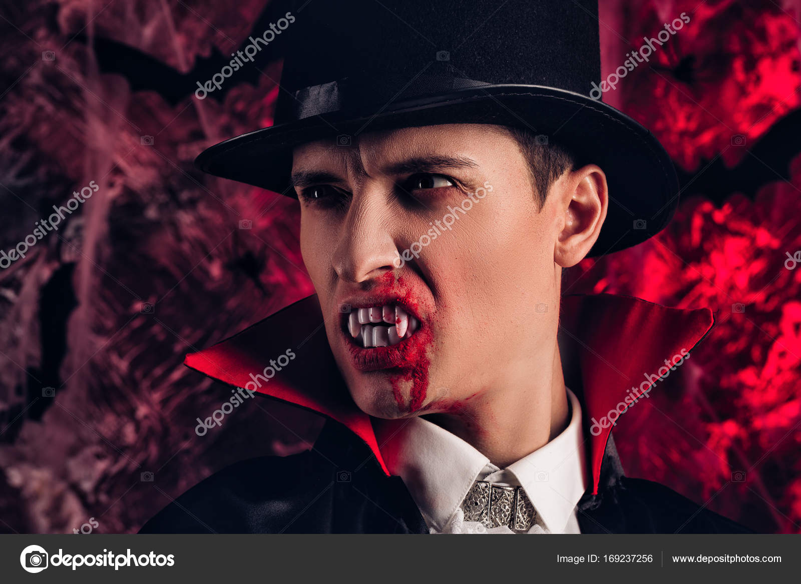 Homem bonito vestido com uma fantasia de drácula para o halloween. vampiro  atraente com velas estende a mão para frente