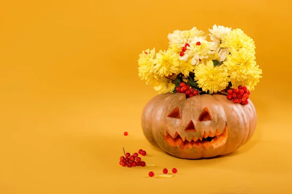 Bouquet of  yellow flowers in pumpkin. Halloween — Stock Photo, Image