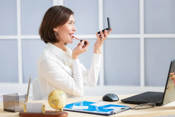 Affärskvinna som gör smink på kontoret — Stockfoto