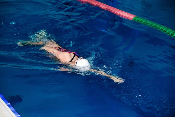 Mulher nadando com chapéu de natação na piscina — Fotografia de Stock