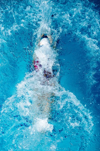 Жінка плаває з капелюхом у басейні — стокове фото