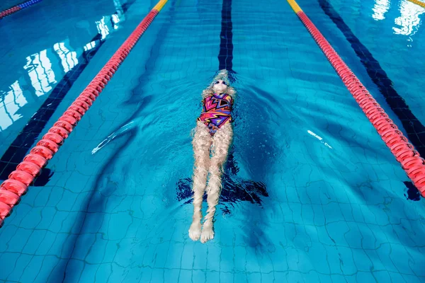 Kvinna som simma med simning hatt i poolen — Stockfoto