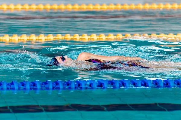 Frau schwimmt mit Badehut in Schwimmbad — Stockfoto