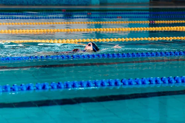 Γυναίκα κολύμπι με φοράτε σκουφάκι στην πισίνα — Φωτογραφία Αρχείου