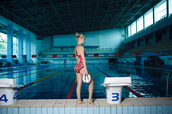 Mujer atlética de pie frente a la piscina — Foto de Stock