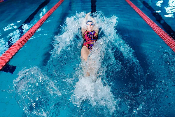 Frau schwimmt mit Badehut in Schwimmbad — Stockfoto