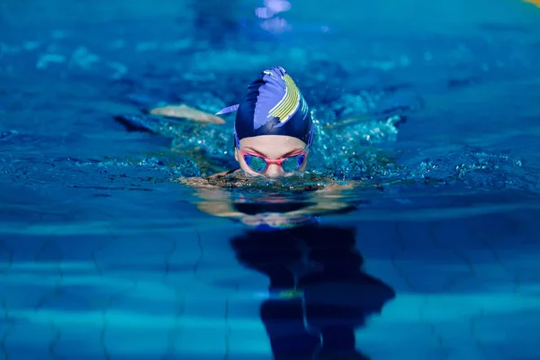 Mulher nadando com chapéu de natação na piscina — Fotografia de Stock