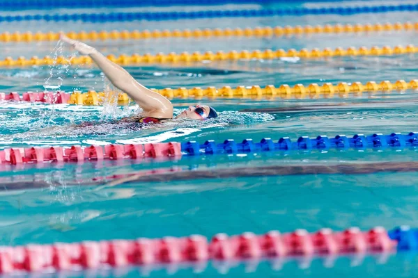 Kvinna som simma med simning hatt i poolen — Stockfoto