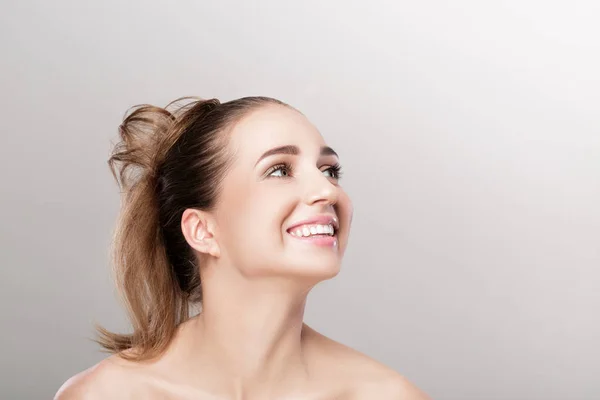 L mujer sonriente sobre fondo gris — Foto de Stock