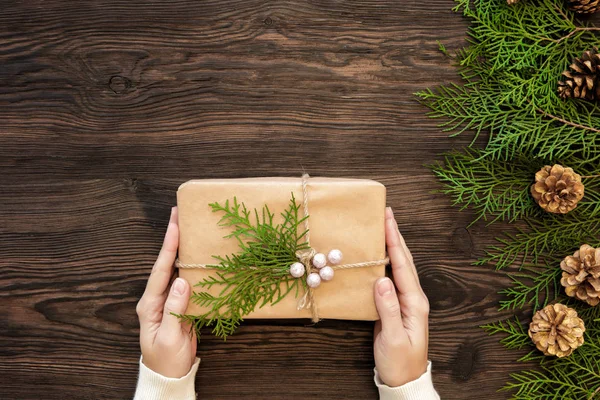 Vrouwelijke handen houden kerstcadeau — Stockfoto