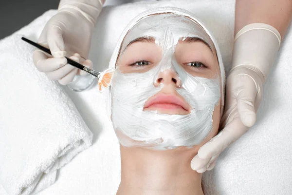 Schoonheidsspecialiste toepassing masker op het gezicht van de vrouw — Stockfoto