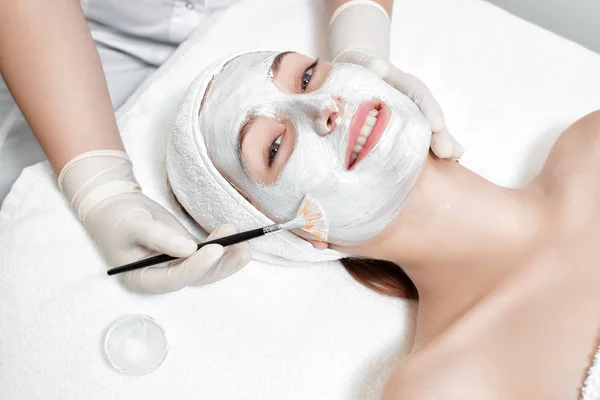 Beautician applies mask to the face of  woman — Stock Photo, Image