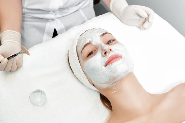 Beautician applies mask to the face of  woman — Stock Photo, Image