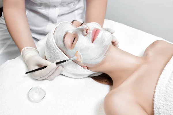 Beautician applies mask to the face of  woman — Stock Photo, Image