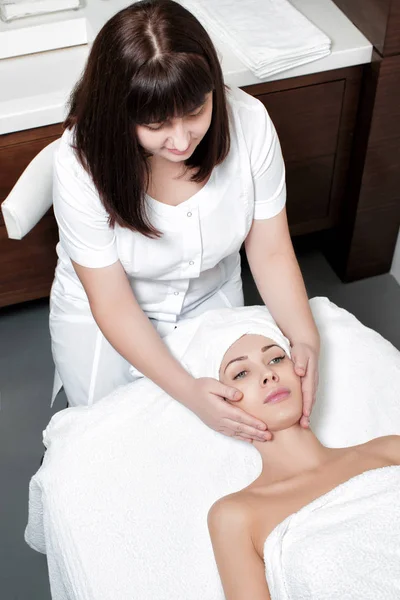 Vrouw ontvangt gezichtsmassage in Spa salon — Stockfoto