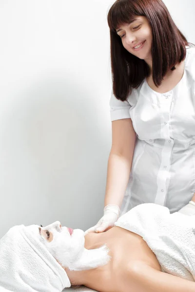 Schoonheidsspecialiste toepassing masker op het gezicht van de vrouw — Stockfoto