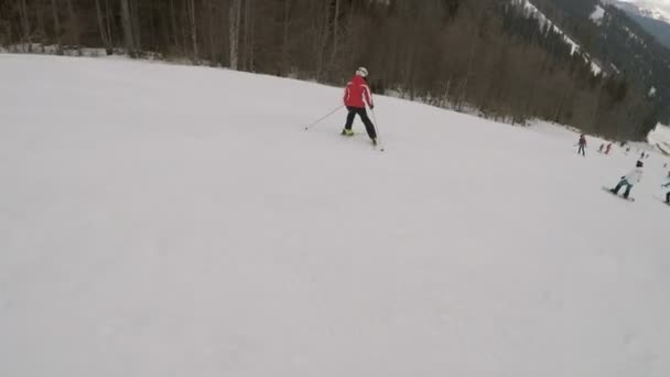 Skiërs naar beneden skiën op de hellingen in Boekovel skigebied. — Stockvideo