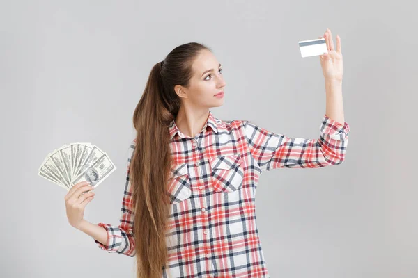 Mujer tiene billetes de dólar y tarjeta de plástico . — Foto de Stock