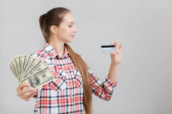 Mujer tiene billetes de dólar y tarjeta de plástico . — Foto de Stock
