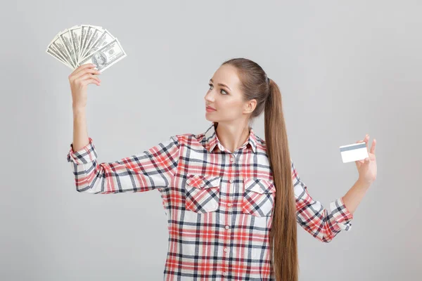 Mujer tiene billetes de dólar y tarjeta de plástico . — Foto de Stock