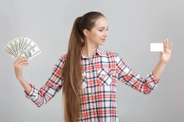 女性は、ドル紙幣とプラスチック製のカードを保持しています。. — ストック写真
