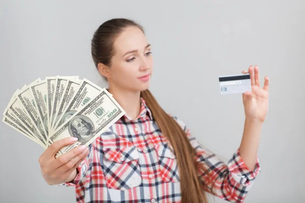 女性は、ドル紙幣とプラスチック製のカードを保持しています。. — ストック写真