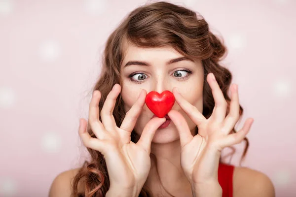 Kvinna med röda hjärtan på rosa bakgrund. — Stockfoto
