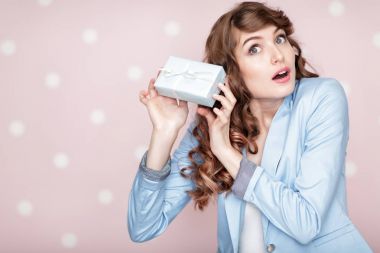 kadın mavi ceketli hediye kutusu tutar.