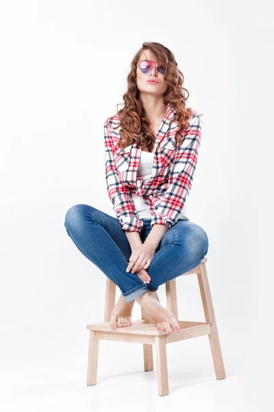 Женщина в джинсах, клетчатой рубашке и солнечных очках — стоковое фото
