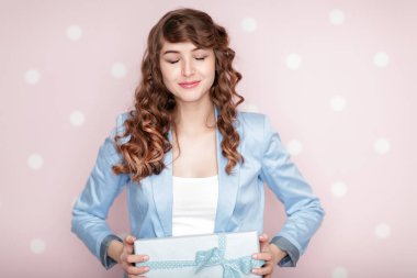 kadın mavi ceketli hediye kutusu tutar.