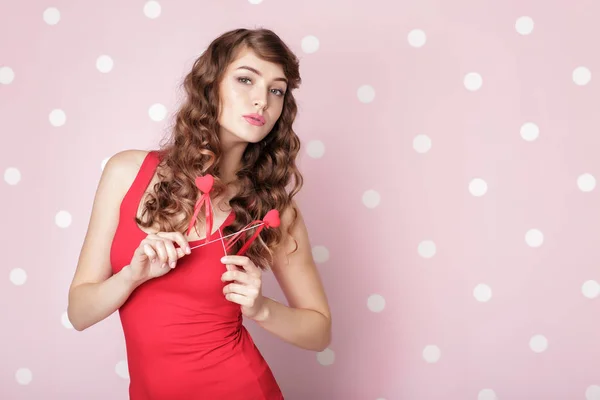 Woman with red hearts on pink background. — Stock Photo, Image