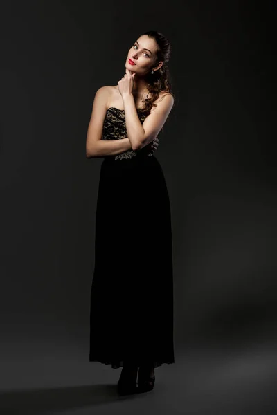 Красивая кудрявая женщина в черном платье — стоковое фото