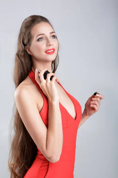 Vrouw in rode jurk met parfum — Stockfoto