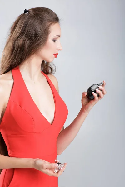 Femme en robe rouge avec parfum — Photo