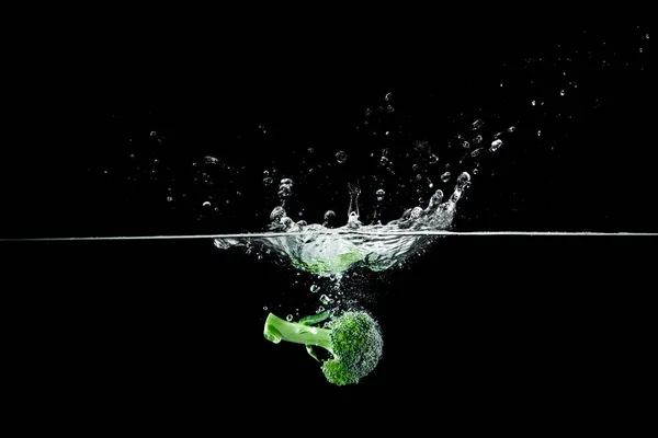 Broccoli in water met splash — Stockfoto