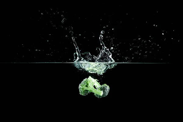 Broccoli in water met splash — Stockfoto