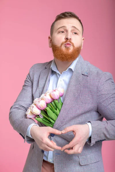 Hombre guapo sosteniendo ramo de tulipanes — Foto de Stock