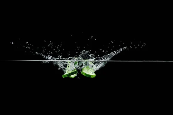 Komkommer in water met splash — Stockfoto