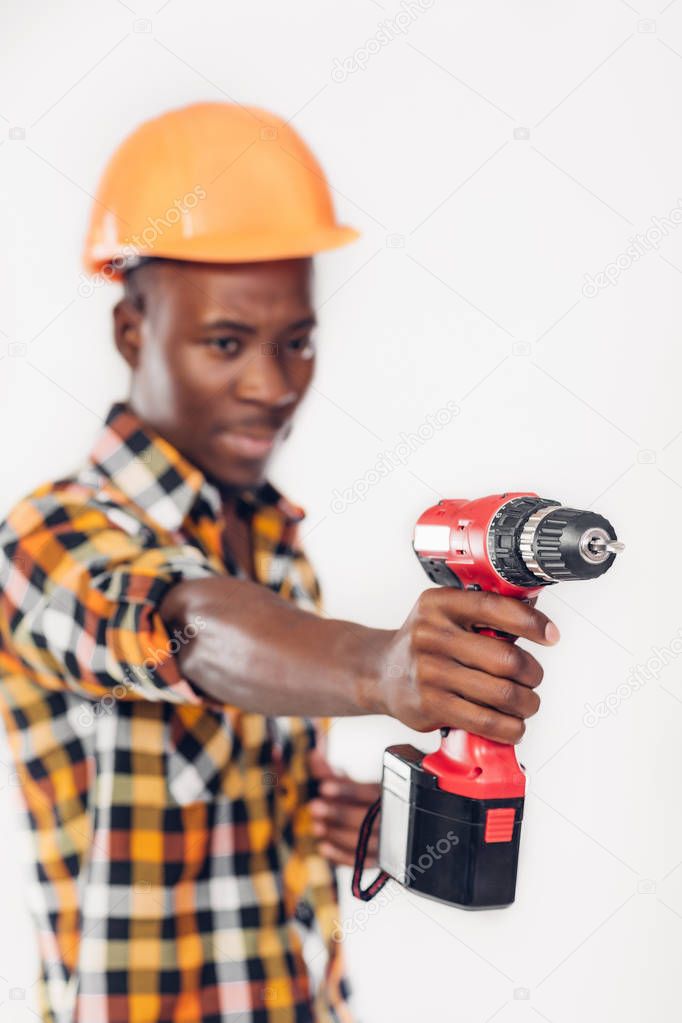 African American worker uses electric screwdriver