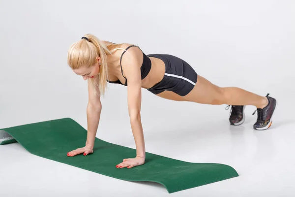 Mulher faz exercícios sobre fitness Mat — Fotografia de Stock