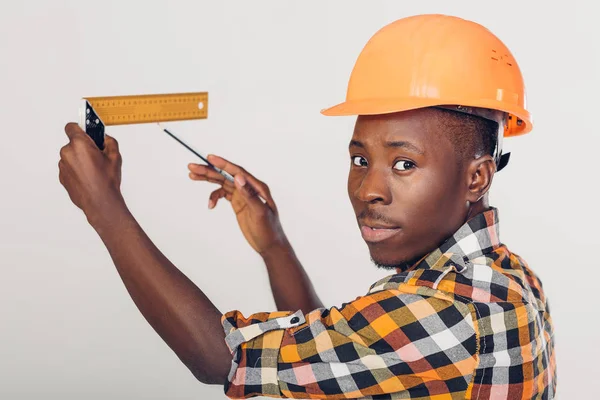 Costruttore afro-americano utilizza nastro di misura — Foto Stock