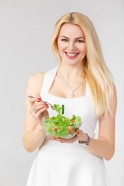 Femme en robe blanche avec salade fraîche — Photo