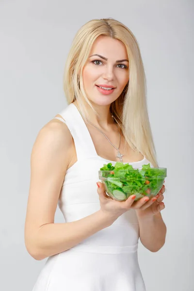 Mulher de vestido branco com salada fresca — Fotografia de Stock