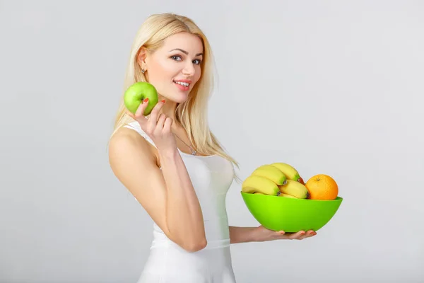 Kvinna i vit klänning visar färska äpplen. — Stockfoto