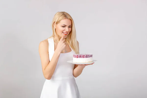 Woman in white dress holding cake — Stock Photo, Image